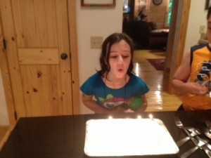 Thea blowing out candles